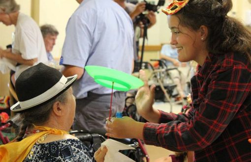 An aged care volunteer happily playing with a resident as part of Whiddon's creative ageing program.