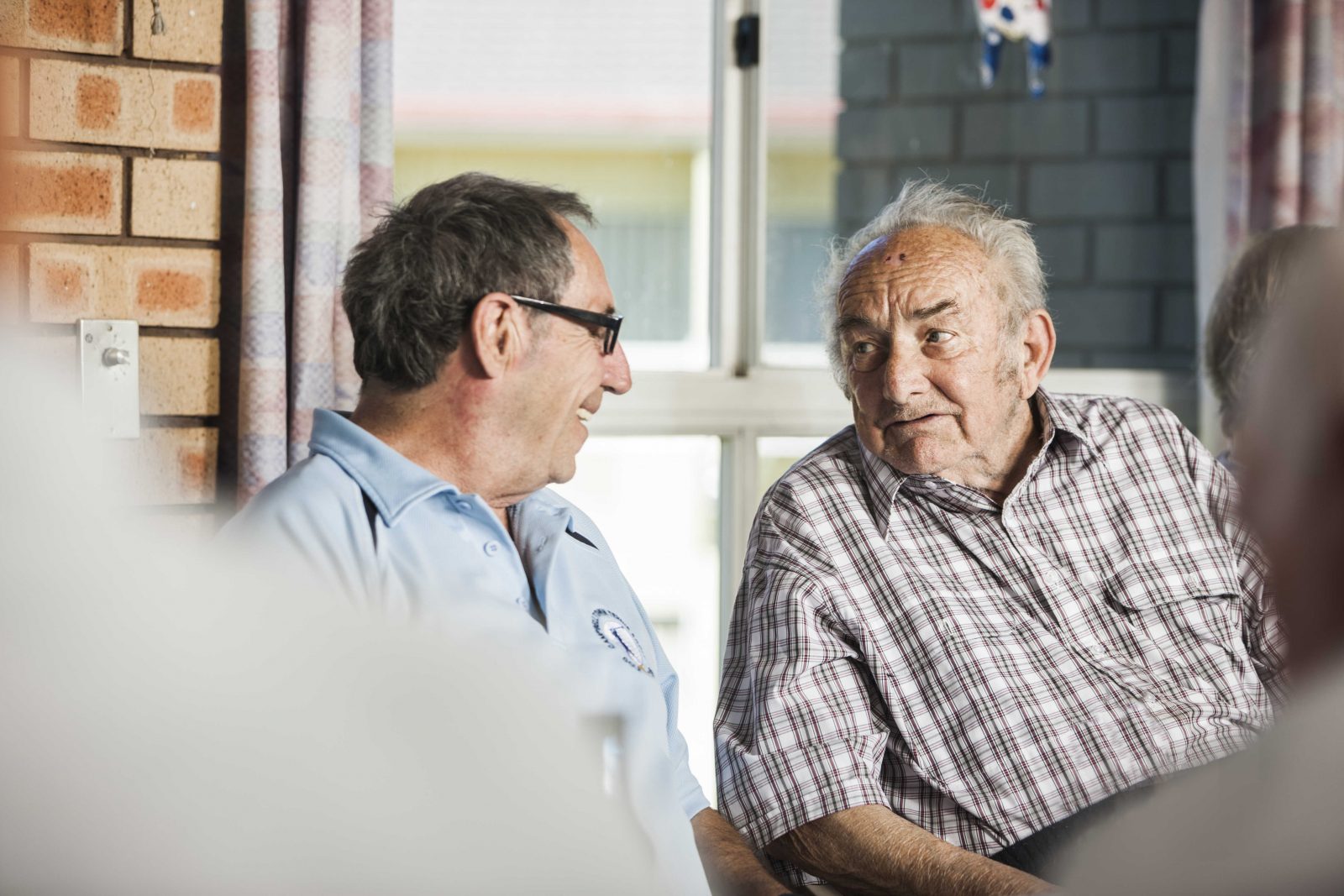 Two men chatting and enjoying their retirement at Whiddon Kyogle, a welcoming residential aged care home.