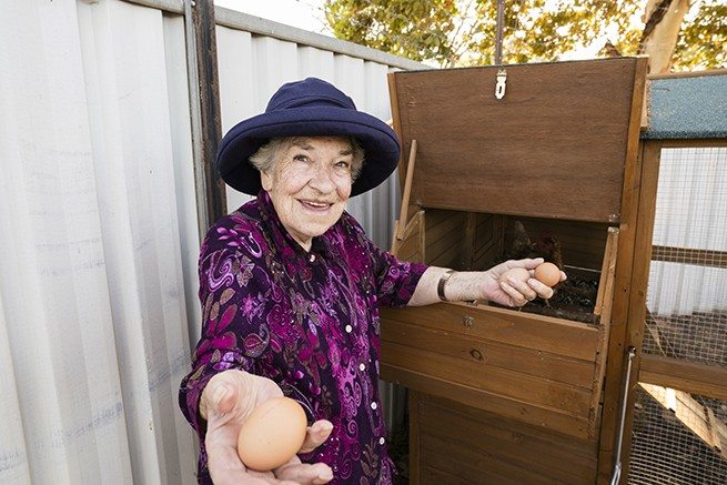 A resident holding eggs that were collected during HenPower, a creative ageing program from Whiddon.