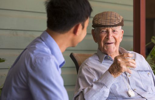 A carer sitting on the porch with a resident and chatting inside Whiddon Hornsby's aged care home.