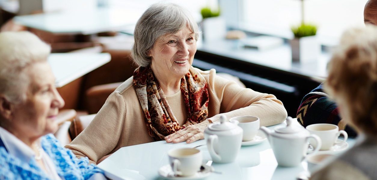 Older woman enjoying a chat with friends at a Whiddon home,