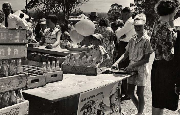 A black and white photo of a community fair, highlighting Whiddon's long term involvement with local communities.