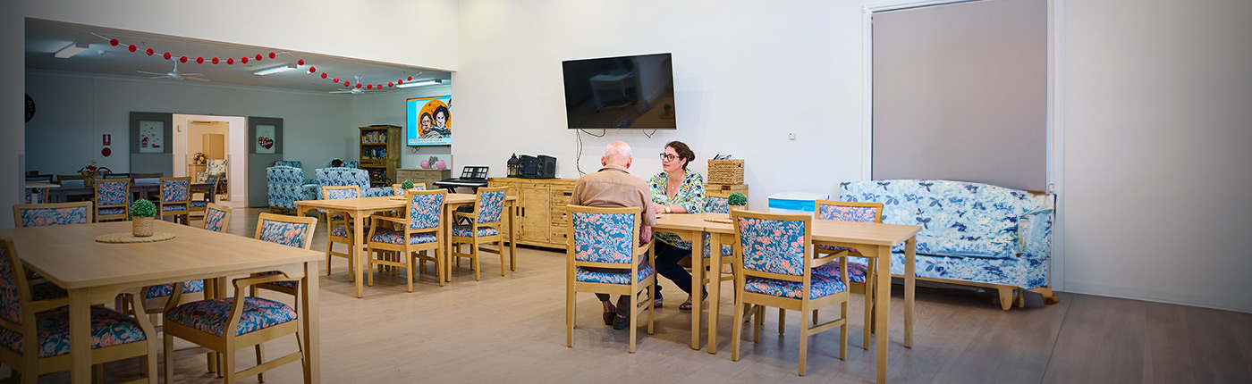 resident sitting at dining table with leisure manager