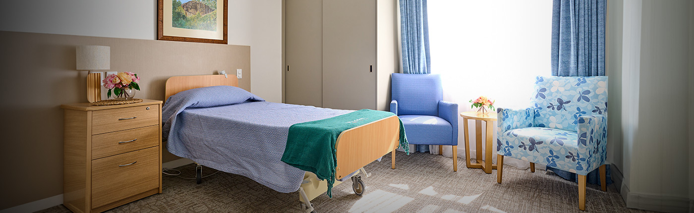 photo of room with bed and blue chair by the big window