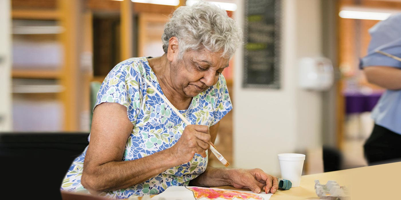 A resident happily painting during one of Whiddon's creative ageing program sessions.