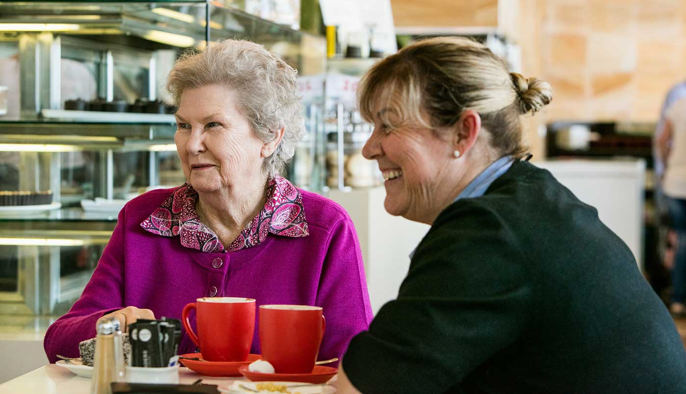 A Whiddon carer and resident from Whiddon's nursing home in Bathurst seen enjoying coffee together at a social outing.