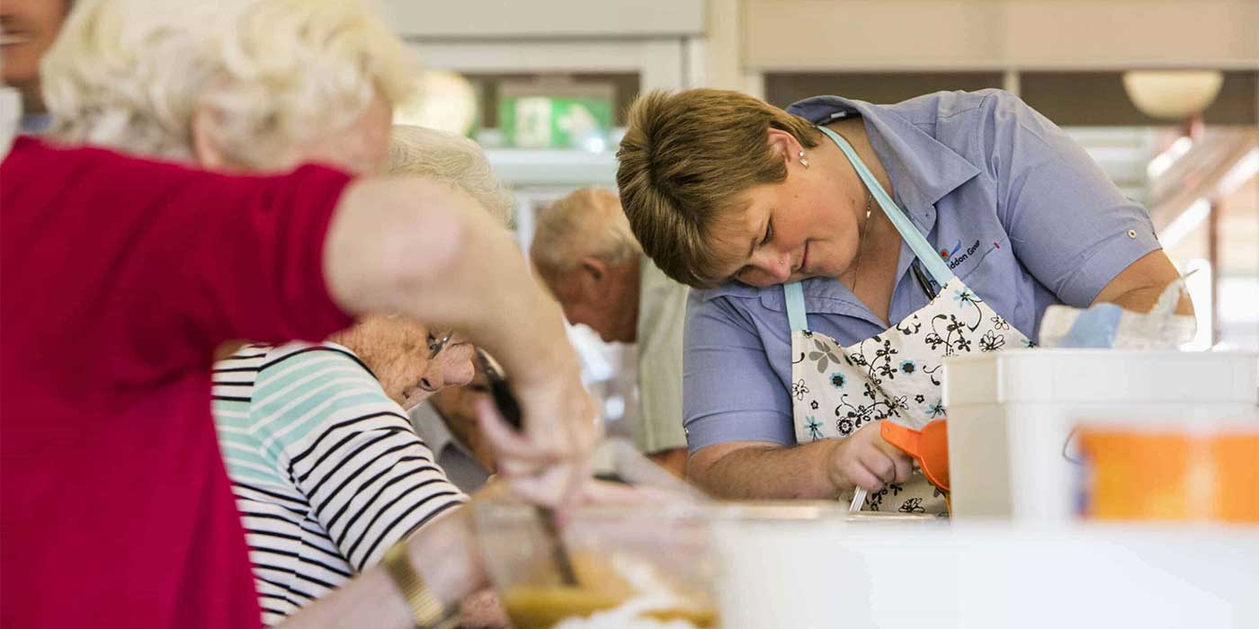 A Whiddon carer with residents baking at an aged care home in Tamworth.