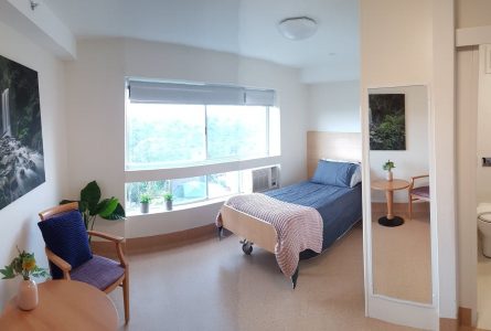 A relaxing bedroom with views of lush greenery at Whiddon's aged care home in Hornsby.