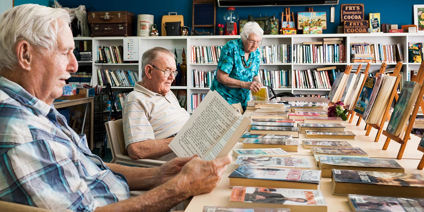 Residents reading books together in the library room at Whiddon Largs, a nursing home in Maitland.