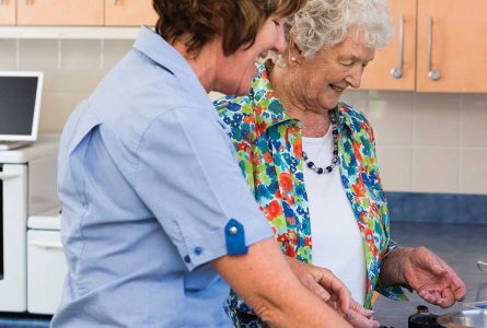 A carer and resident enjoying cooking together at Whiddon's community care home on the mid north coast.