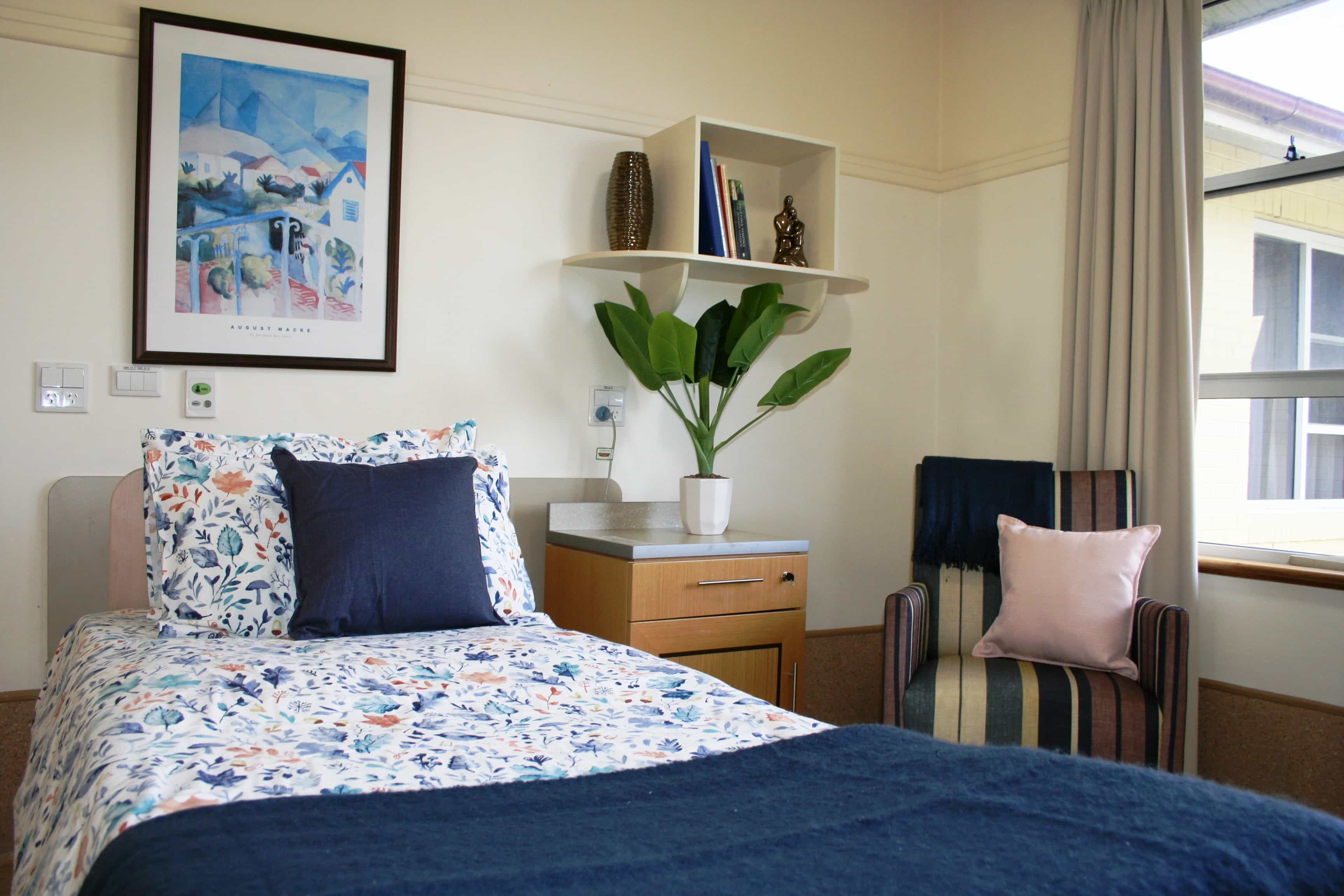 A quaint single bedroom fit with a painting and lush greenery at Whiddon Easton Park, an aged care home in Glenfield.