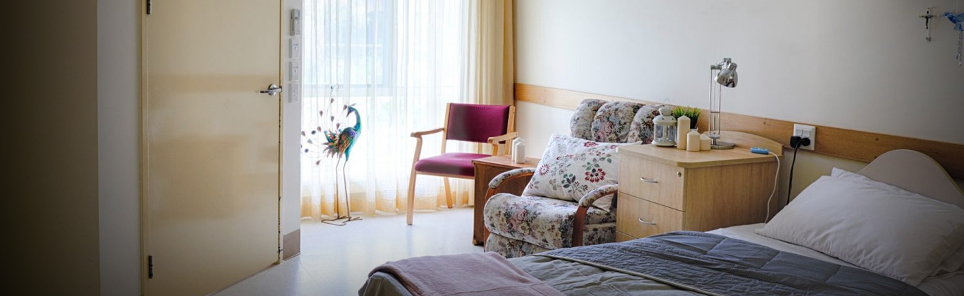 Image of bedroom at Beaudesert with red chair in corner infront of big window