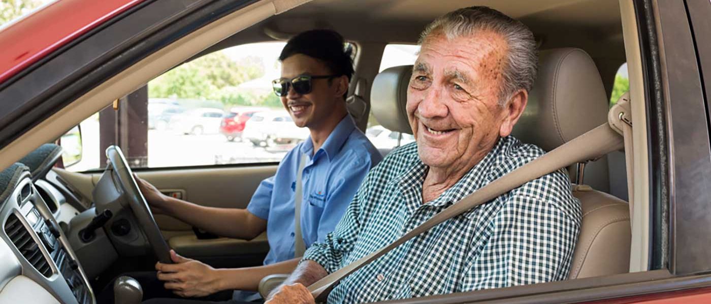 A carer with a resident enjoying a car ride as part of assisted transport services at Whiddon Narrabri.