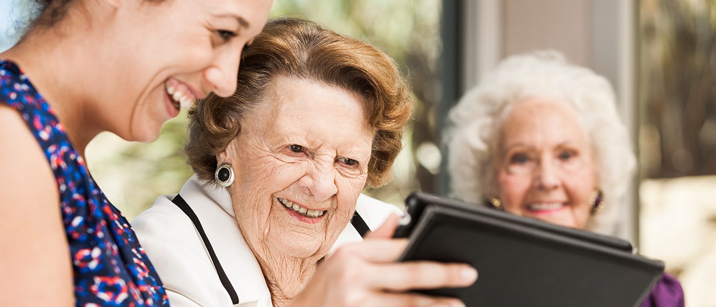 seniors and young person using ipad