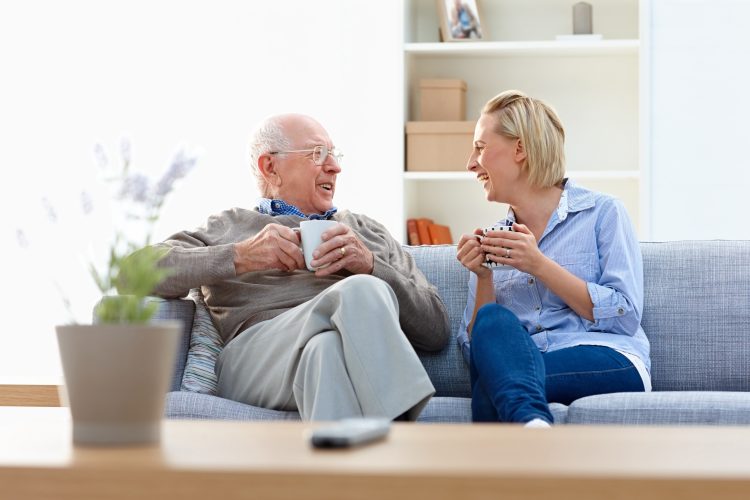 A senior man and female in a living room showcasing Whiddon's retirement village care solutions.