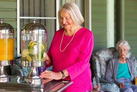 A resident enjoying some refreshing iced lemon water with other residents at Whiddon Narrabri.