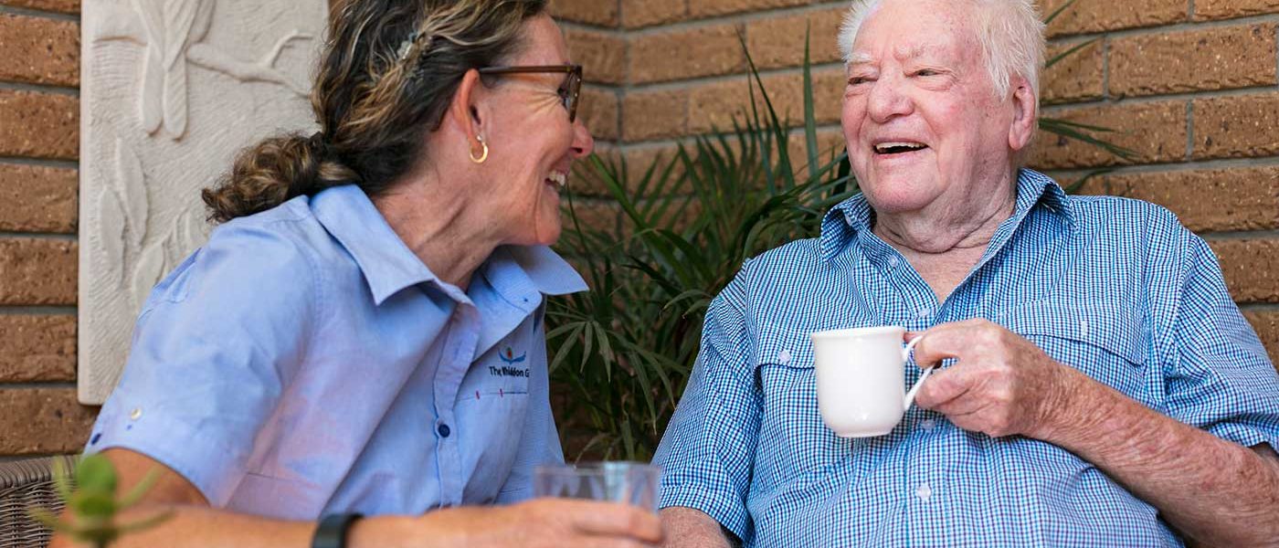 A carer chatting happily with a resident at a Whiddon community care home.