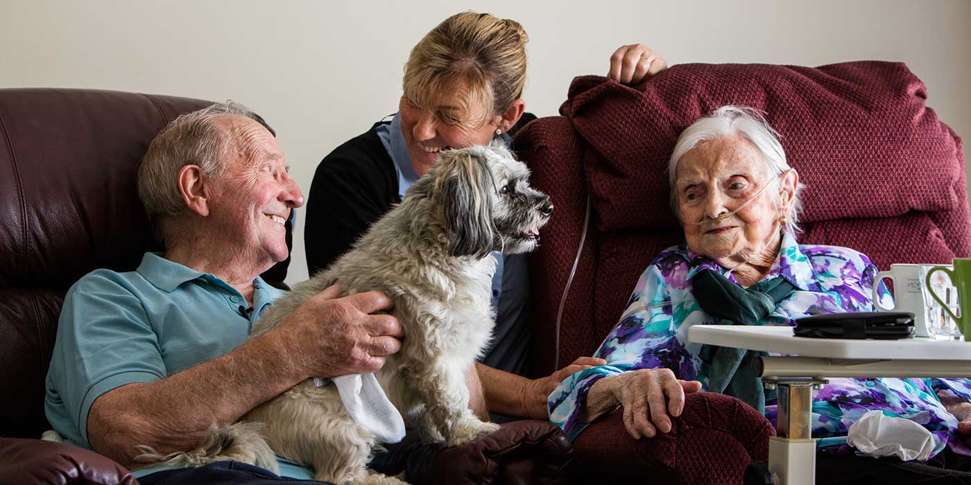Two Whiddon residents spending quality time with a dog and a carer in Whiddon's nursing home in Bathurst.
