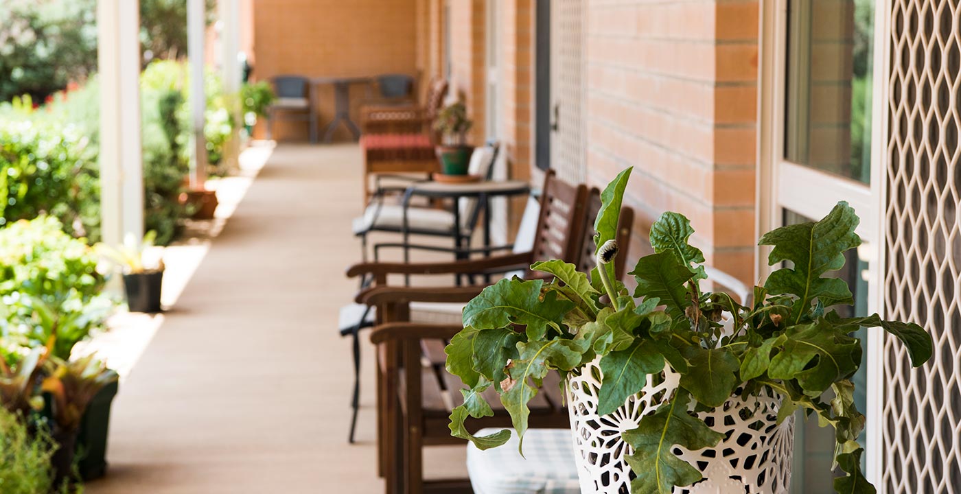 An outdoor seating area surrounded by lush gardens at Whiddon's aged care home in Mudgee.