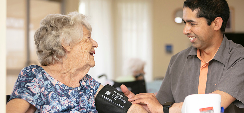 Whiddon community care worker checking clients blood pressure