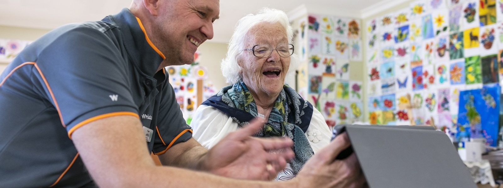 Whiddon employee helping a resident with electronic device