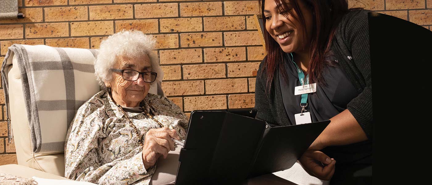 Whiddon employee helps resident to have video chat with the family