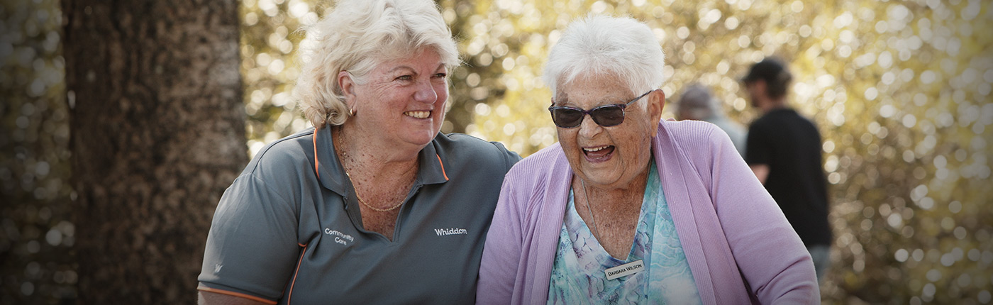 Care worker with a resident smiling and being happy together