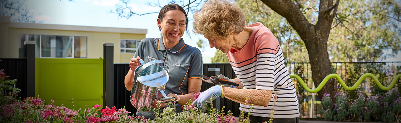 care worker and resident gardening together