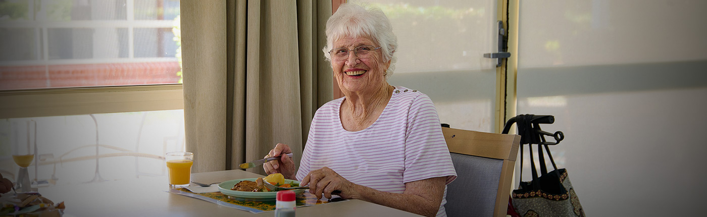resident enjoying her meal