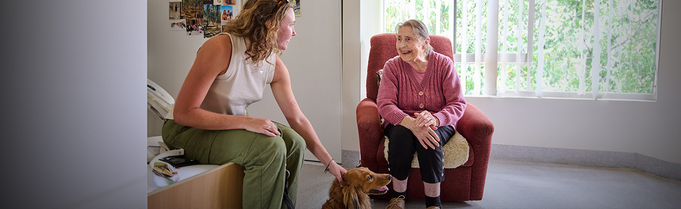 resident with family member patting a dog
