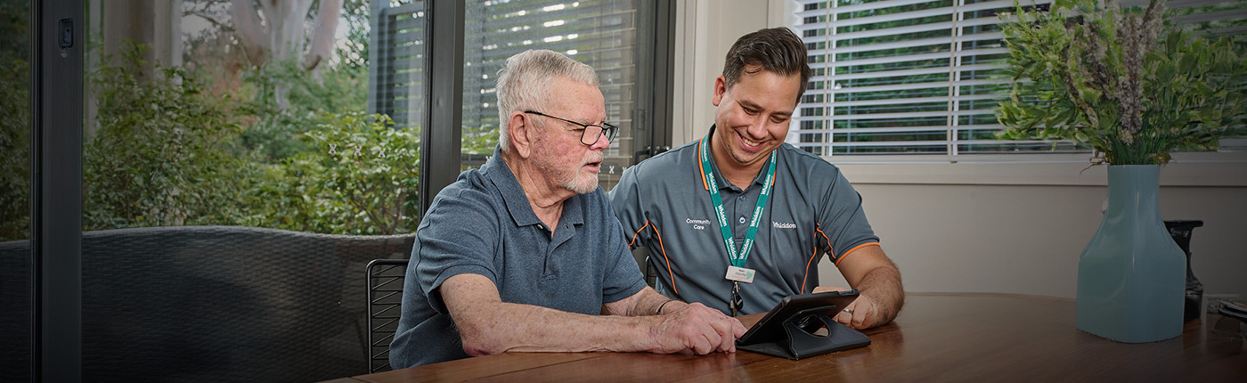 employee helping resident on ipad