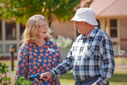 A Carer talkes to a residend while he is watering the garden