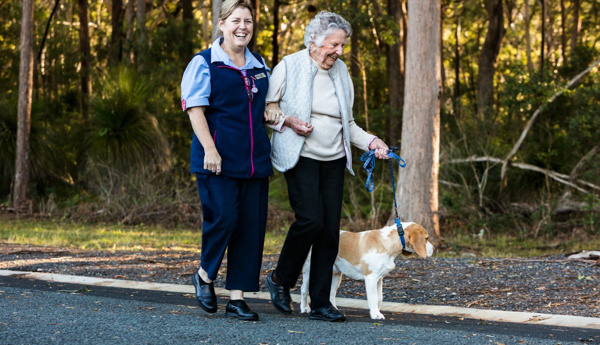 Gloria and Debbie walking Chappy the dog as part of Whiddon's pet therapy program.