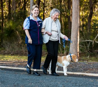 Gloria and Debbie walking Chappy the dog as part of Whiddon's pet therapy program.