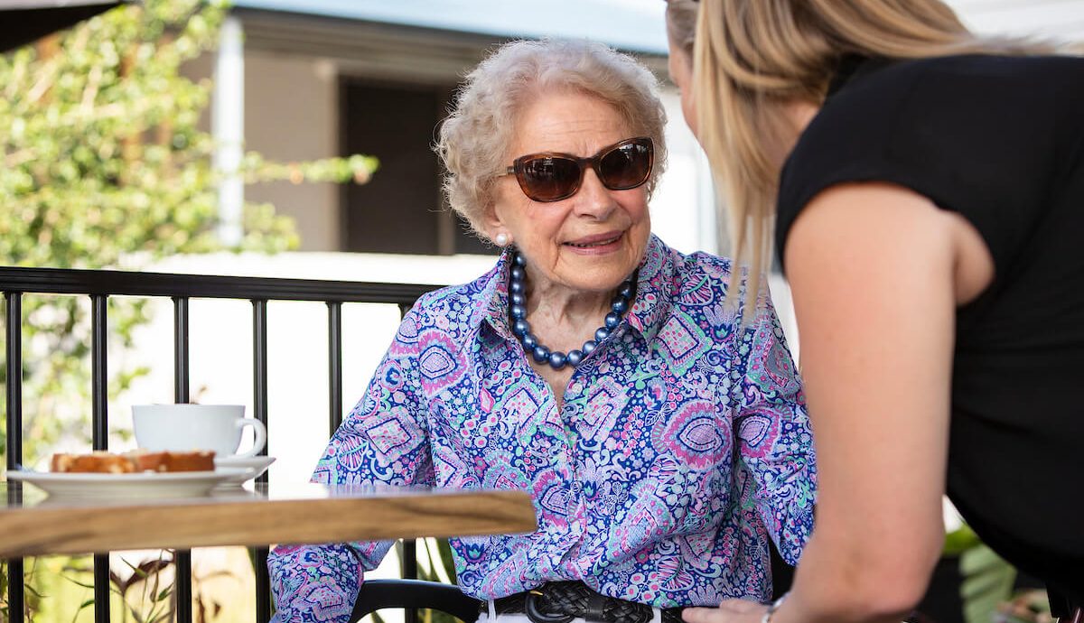 senior lady out at coffee shop with carer