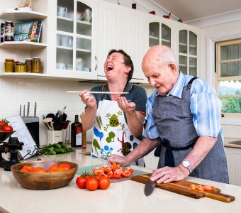 older man cooking at home with care worker