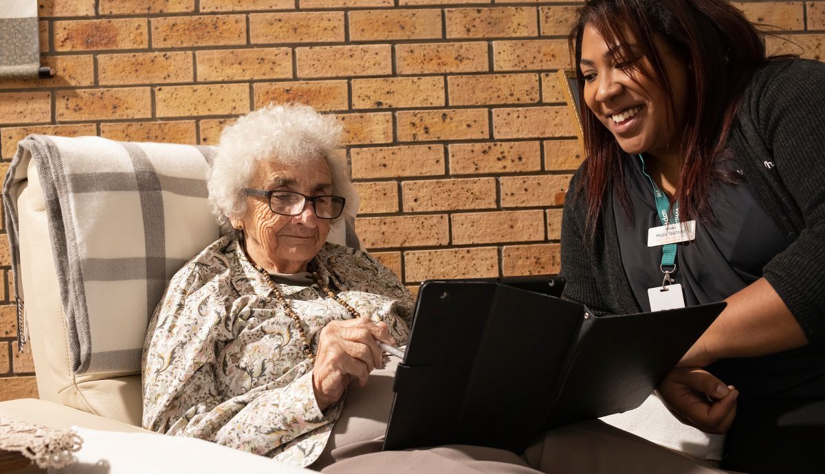 Community Care Coordinator with client looking at an iPad