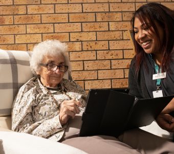 Community Care Coordinator with client looking at an iPad