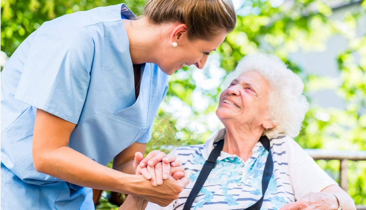 female aged care worker holder senior woman's hand