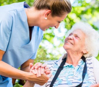 female aged care worker holder senior woman's hand