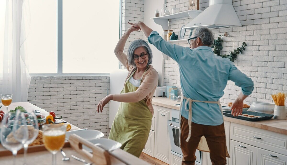 older adults dancing in the kitchen of their unit