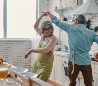 older adults dancing in the kitchen of their unit