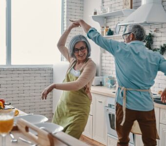 older adults dancing in the kitchen of their unit