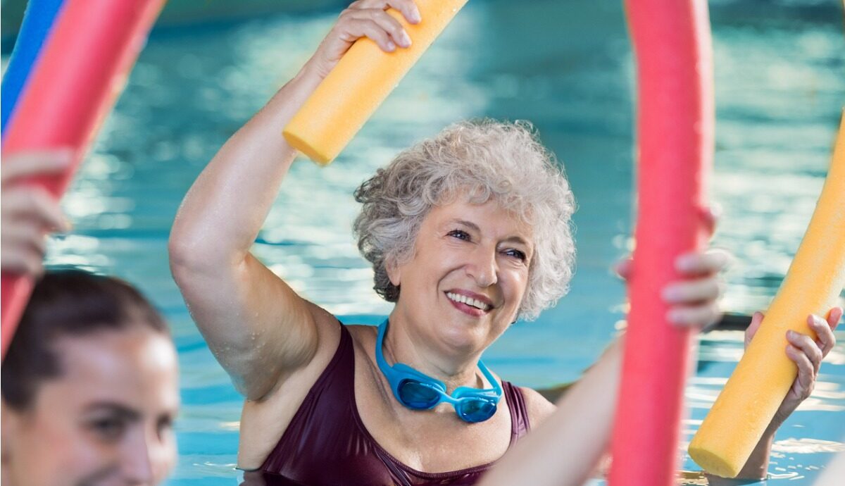 an older woman doing exercises with a noodle in the pool