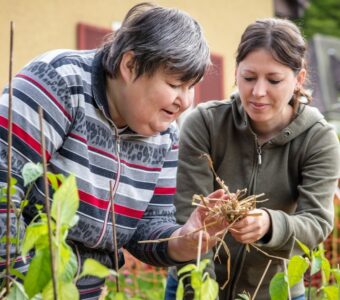 support worker helping woman with disability with gardening