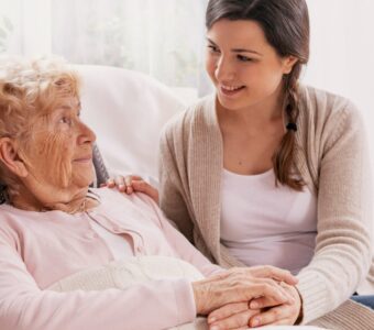 young woman caring for older mother sitting in bed