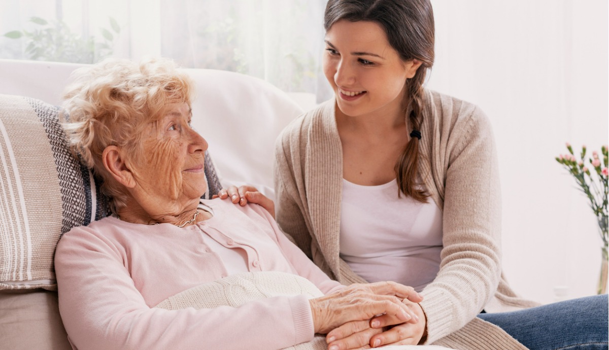 young woman caring for older mother sitting in bed