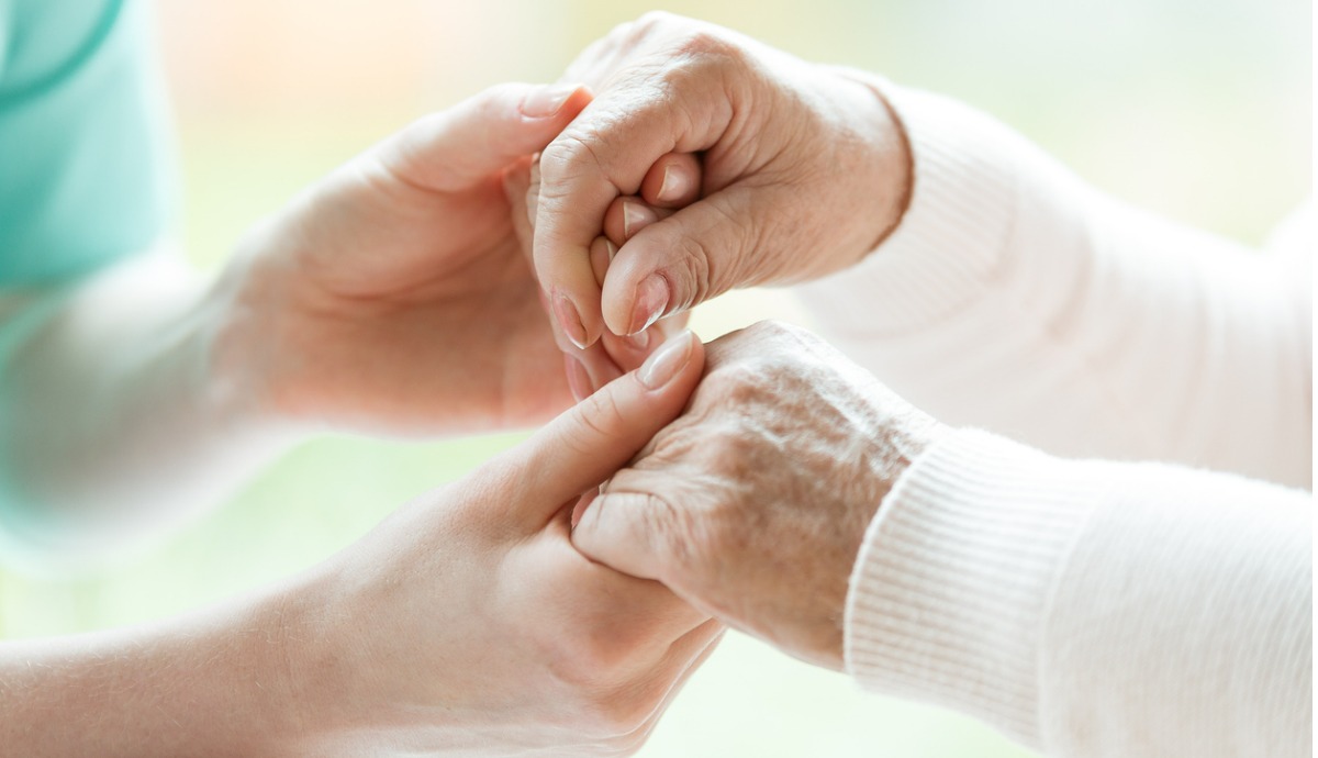 caregiver holding older persons hands