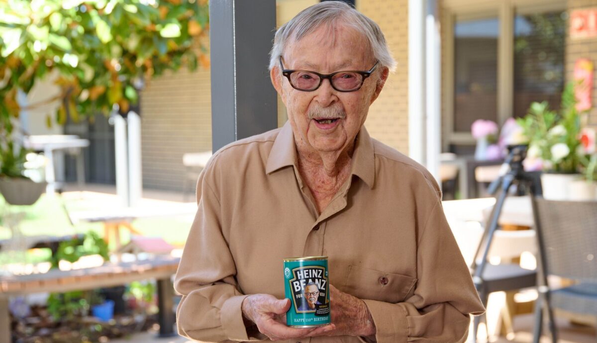 Ken Weeks, smiling and holding his can of personalised Heinz beans.