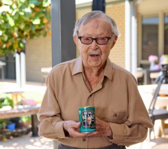 Ken Weeks, smiling and holding his can of personalised Heinz beans.